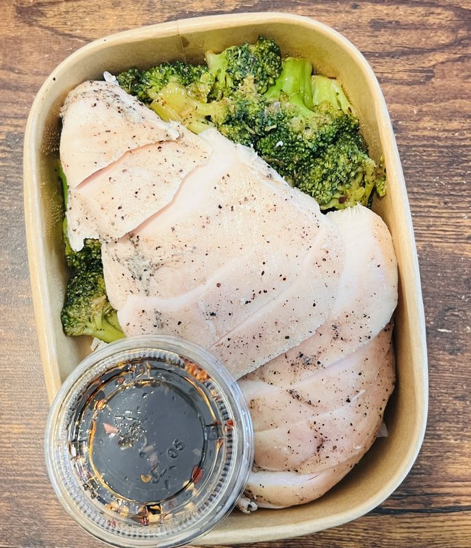 Sliced chicken breast with roasted broccoli and sauce