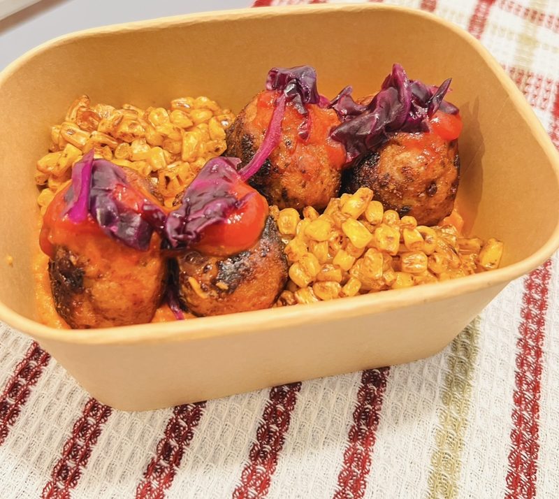 Meatballs in romesco with charred corn and pickled cabbage